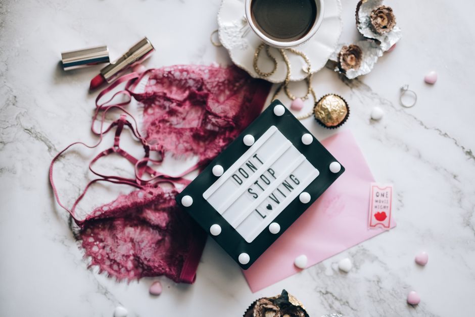 A charming flat lay with coffee, lingerie, and feminine accessories, capturing romance and elegance.