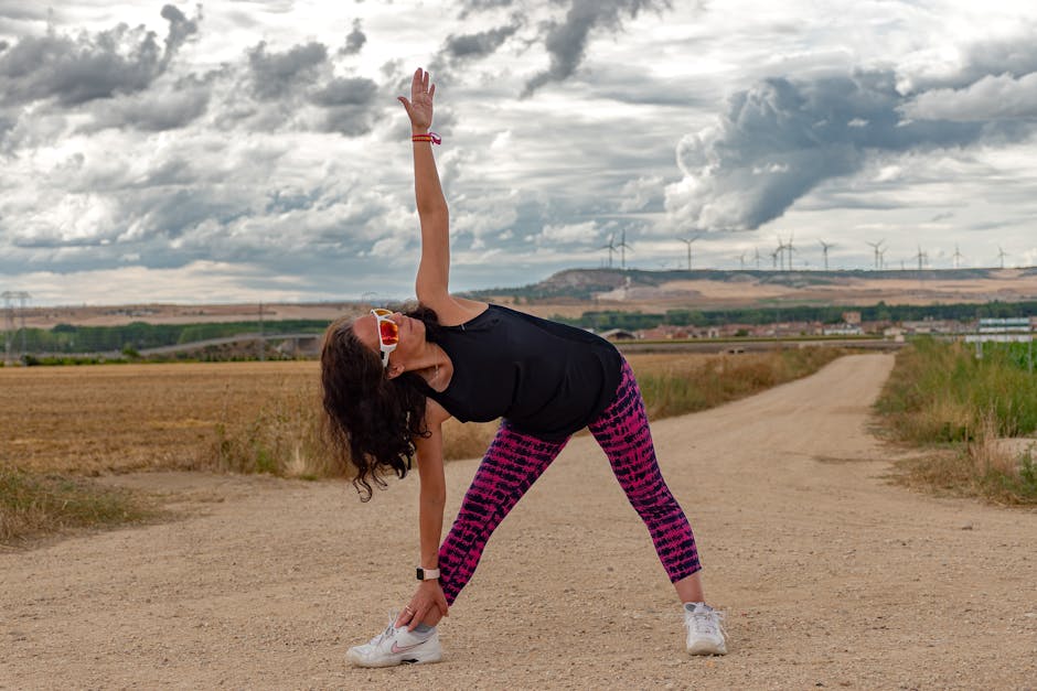 Outdoor fitness scene of a woman stretching on a dirt path in Soto de Cerrato amidst scenic landscapes.