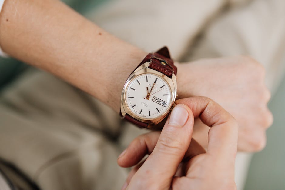 Detailed shot of a hand adjusting a wristwatch on the wrist, focusing on time setting.
