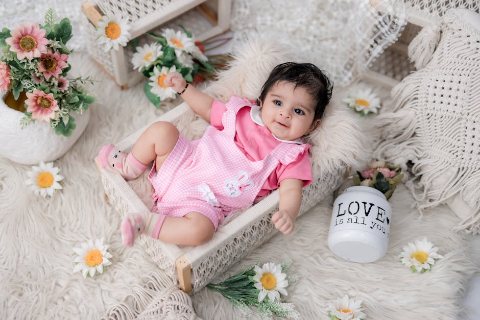 Charming baby in pink romper resting amidst a floral setting, bringing warmth and cuteness.
