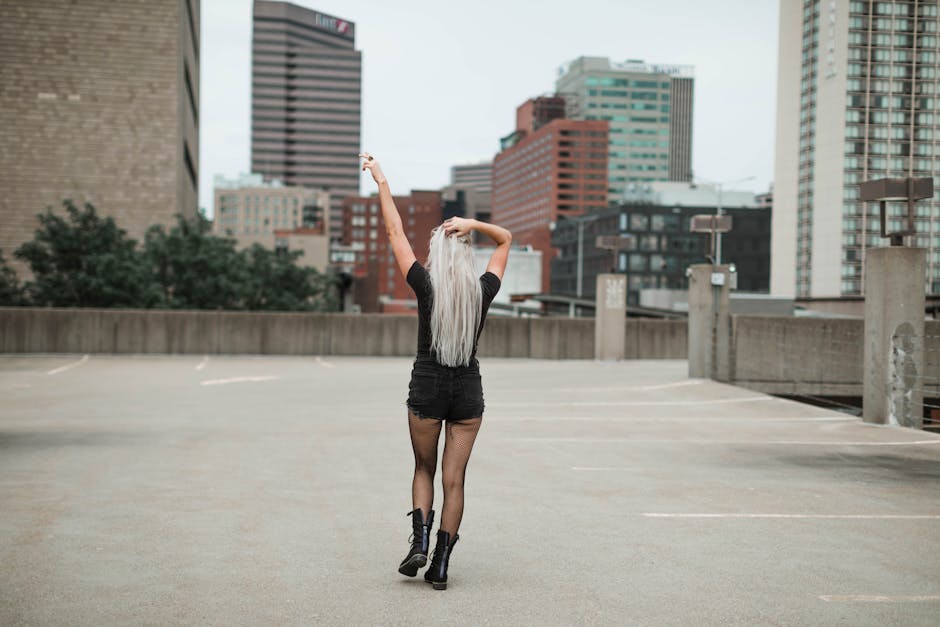 Stylish woman with long hair poses confidently in an urban Cincinnati setting, showcasing fashion and lifestyle.