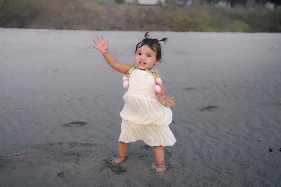 Charming baby girl enjoying a fun day on a sandy beach, dressed in a cute outfit.