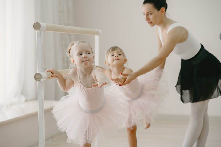 Young girls learning ballet with a teacher in a bright studio.